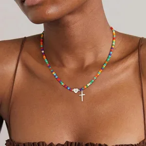Gedetailleerde close-up van kleurrijke kralenketting met hartje letter M en kruishanger.
