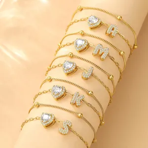 Chaque chevillère dorée présente des charms cœur en zircon et des lettres, réglable.