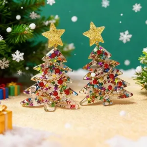 Primer plano detalle de pendientes de navidad acrílicos con estrella dorada y lentejuelas.