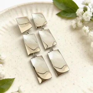 Vista detallada de elegantes pendientes colgantes geométricos multicapa dorados de moda.