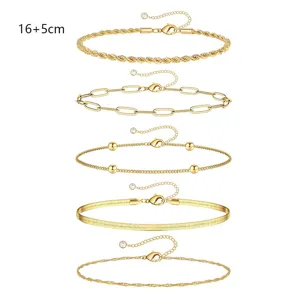 Primer plano detallado de cinco pulseras de cadena dorada con diversos estilos clásicos.