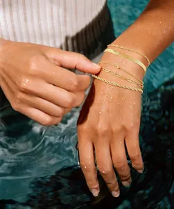 Detalle de pulsera de cadena multicapa dorada, joyería de moda apilable delicada