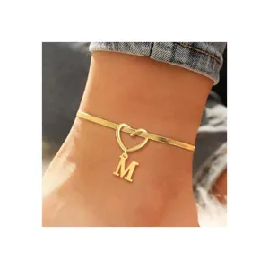 Gold tone herringbone chain anklet featuring a hollow heart link and letter M pendant for women.