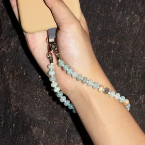 Natural stone phone charm wrist strap detail view, beaded camera accessory for women.