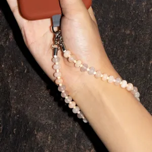 Close-up detail shot of beaded phone wrist strap, natural stone beads, stylish metal clasp.