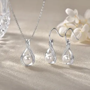 Detailed shot of elegant teardrop pearl necklace and earrings set with shimmering paved stones.
