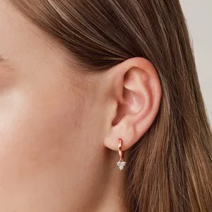 Gros plan détaillé des élégantes boucles d'oreilles en zircone rose portées à l'oreille.