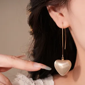 Gros plan de boucles d'oreilles cœur vintage en or, design élégant pour femmes.