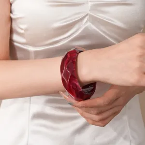 Red acrylic faceted bangle bracelet detail view showcasing marble texture and stylish design.