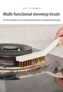 Close-up view of a white wire brush cleaning greasy stains off a kitchen gas stove burner