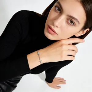 Detailed view of silver letter heart cross bracelet, chic minimalist wrist chain for women style.