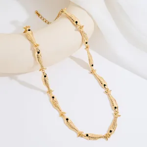 Detalle de collar de cadena de peces dorados, primer plano de joyería metálica elegante para mujeres.