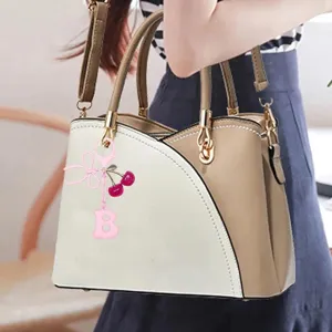 Cute cherry pendant keychain with pink bow and letter charm for women handbags and car keys.