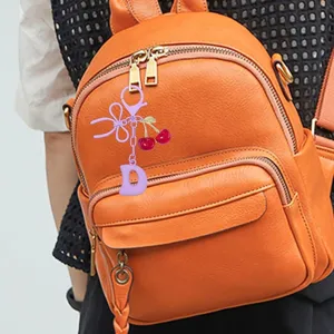 Cute cherry bow letter D bag charm keychain, stylish accessory for women backpacks and car keys.