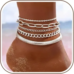 Detail shot of layered silver anklets featuring various chain designs for beach travel.