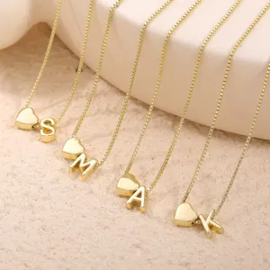 Collana in rame dorato con ciondolo a cuore e iniziale alfabetica dal design raffinato.