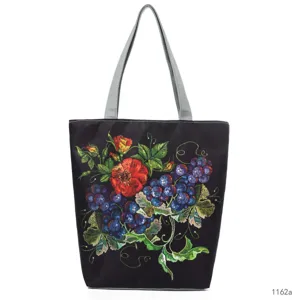 Exquisite floral and grape embroidery detail on a classic black fabric tote bag with gray straps.
