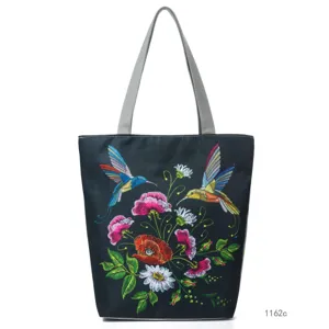 Elegant black tote bag with colorful hummingbird and flower embroidery, spacious and stylish.
