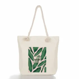Sac cabas en toile pour femme avec motif de feuilles tropicales et poignées solides.
