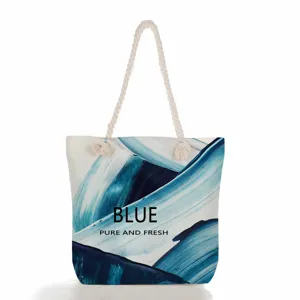 Gros plan sur les details du sac cabas en toile abstraite bleue, poignee en corde.