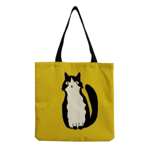 Close-up detail of the yellow canvas tote bag featuring a cute black and white cat graphic.