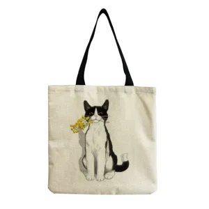 Canvas tote bag with cute black and white cat print holding yellow flowers, casual retro style.