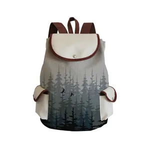 Canvas backpack detail showing forest tree print, brown straps, and front flap pocket design.