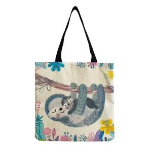 Gros plan sur les détails du sac cabas en toile avec un motif de paresseux et de fleurs.