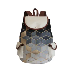 Detailansicht des geometrischen Leinwand-Rucksacks mit goldenen Würfeln und Lederbesatz.