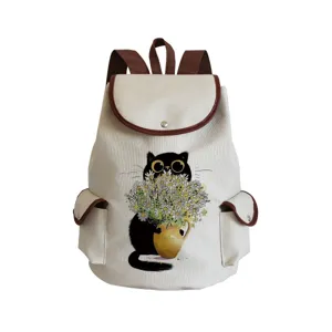 Détail de sac à dos en toile avec adorable imprimé chat noir et bordure en cuir.