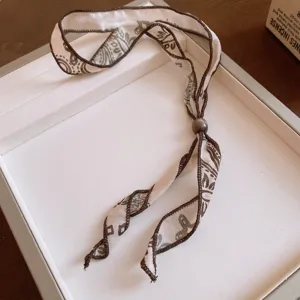 Gargantilla de tela retro con colgante de cuenta acrílica y diseño floral vintage.