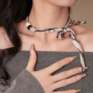 Vista detallada del collar gargantilla de tela retro con colgante de acrílico único y elegante.