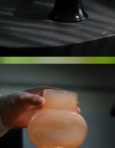 Détail de bougeoir en verre translucide orange et socle sombre texture élégante.