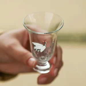 Handmade glass tea cup featuring white crane design, elegant personal tea mug for office use.