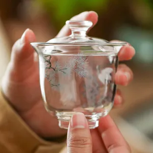 Clear glass gaiwan tea cup with pine and crane design, perfect for home kung fu tea set.