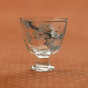 Taza de té de vidrio con tallo alto y diseño de pino y grulla tradicional vista principal
