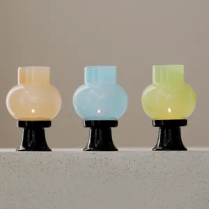 Ensemble de trois bougeoirs en verre coloré avec des bases noires pour la décoration intérieure.