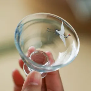 Elegant glass tea cup featuring white crane painting, perfect for kung fu tea ceremony.