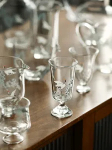 Élégant service à thé en verre de style chinois avec des motifs de grues blanches délicates.