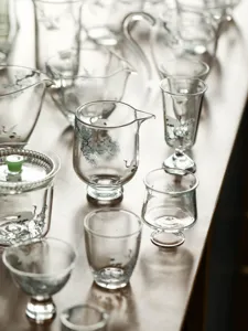 Set de tasses à thé en verre avec motif de pin et de grue, détail d'ustensiles de thé.