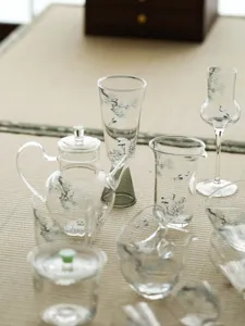 Détail du service à thé en verre pin et grue avec des tasses peintes pour la cérémonie du thé.