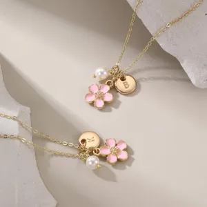 Vue détail du collier lettre plaqué or avec pendentif fleur émail rose et perle charm élégant.
