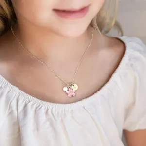 Détail de collier doré délicat avec pendentif fleur rose et perle pour femme.