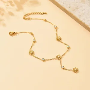Vista di dettaglio della cavigliera dorata floreale con strass e perle, gioiello elegante.