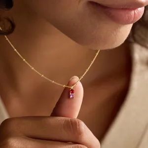 Minimalist gold clavicle necklace with dainty red and pink birthstones for women fashion.