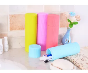 Close-up of pastel portable toothbrush travel cases in a bathroom setup.