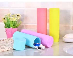 Close-up detail of colorful candy-colored portable toothbrush cases in a bathroom.
