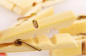 Close-up macro detail of natural bamboo clothespin showing wood grain and metal spring