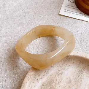 Brazalete de resina beige irregular, detalle de joyería retro de diseño minimalista.