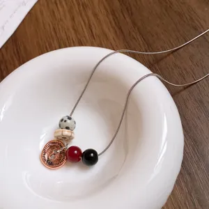 Primo piano dettaglio della collana di perle in acciaio inossidabile con pietra dalmata.
